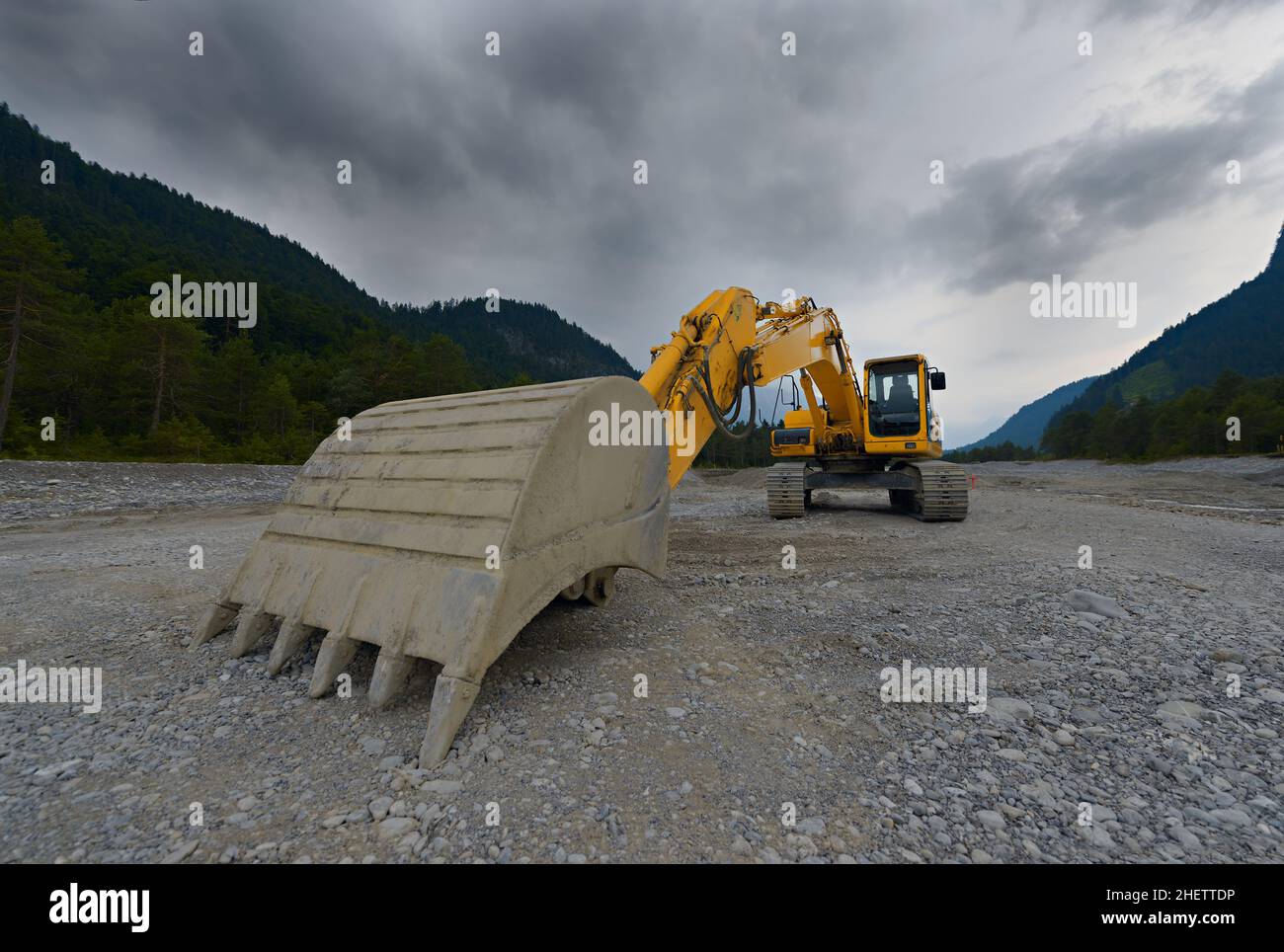 orange mechanical shovel excavator or bucket digger on gravel Stock