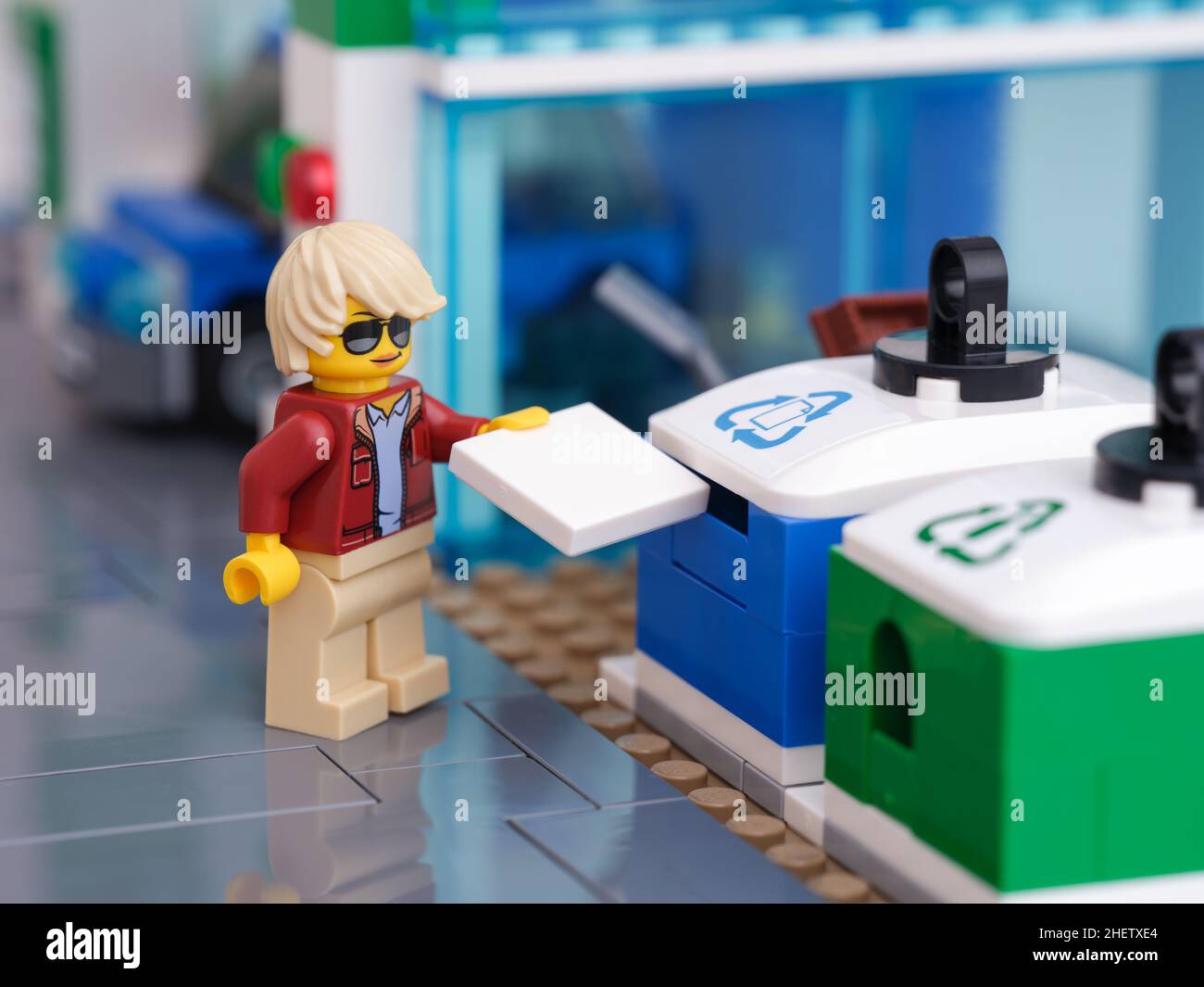 Tambov, Russian Federation - January 11, 2022 A Lego woman minifigure putting a piece of paper into a recycling bin for paper. Close up. Stock Photo