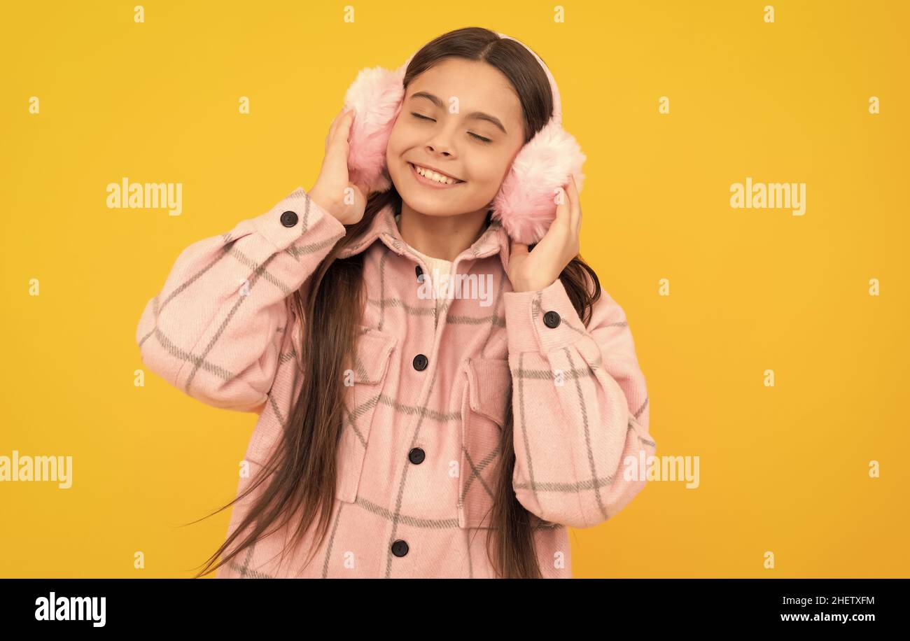 Warmth to touch. Happy child enjoy warmth of fur earmuffs. Fashion winter accessories Stock Photo