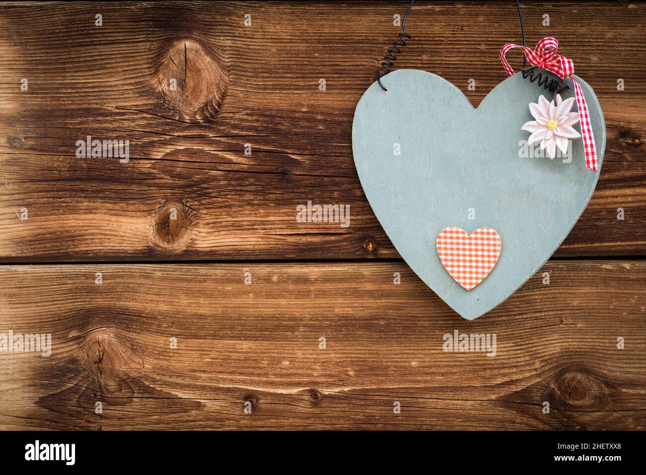 wooden grey heart with edelweiss on sun burned wood planks Stock Photo