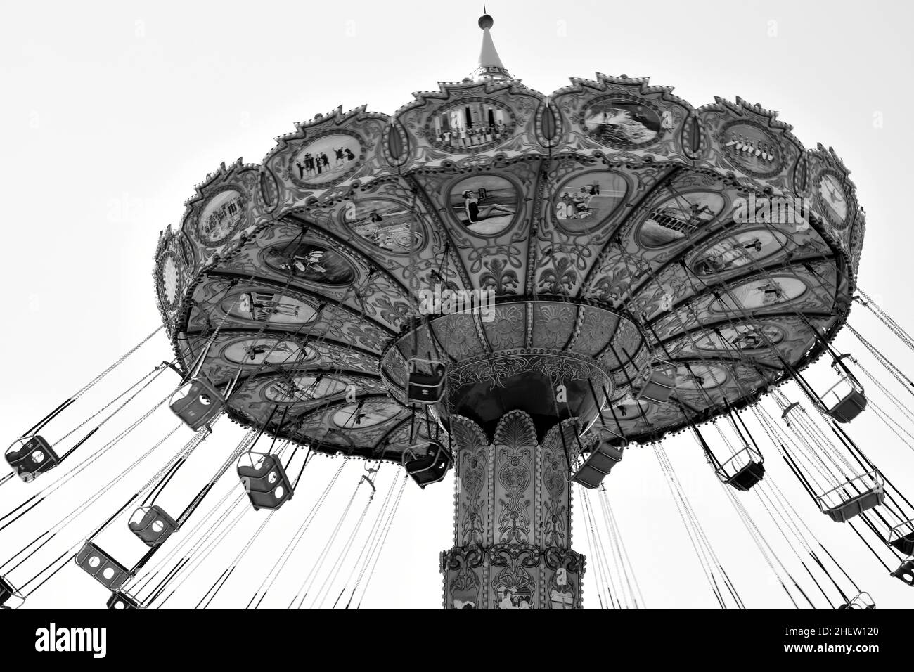 Monochrome Old Twirling Carnival Ride with Swinging Seats and Detailed Paintings Stock Photo