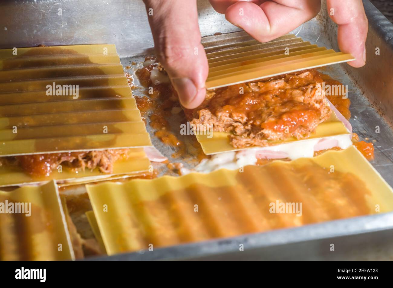 lasagna in an aluminum pan, spatula taking a piece of the pan, selective  focus Stock Photo - Alamy
