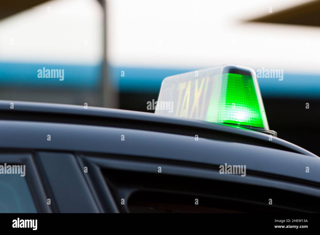 Closeup of a green light on a taxi cab indicating that it is available for hire as it waits in line Stock Photo