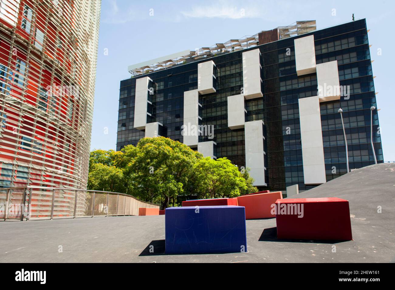 Urban environment with modern skyscrapers and a cement walkway with rectangular blocks for seating Stock Photo