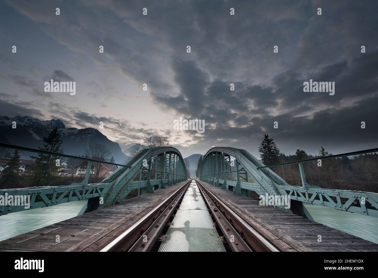 mystical train bridge made of steel and dramatic sky at sunset Stock Photo