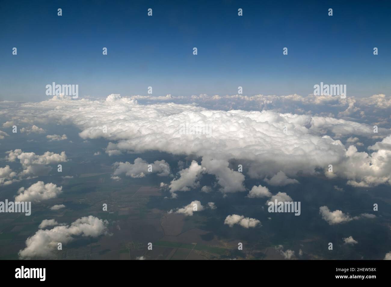 Aerial view from airplane window of white puffy clouds on bright sunny ...