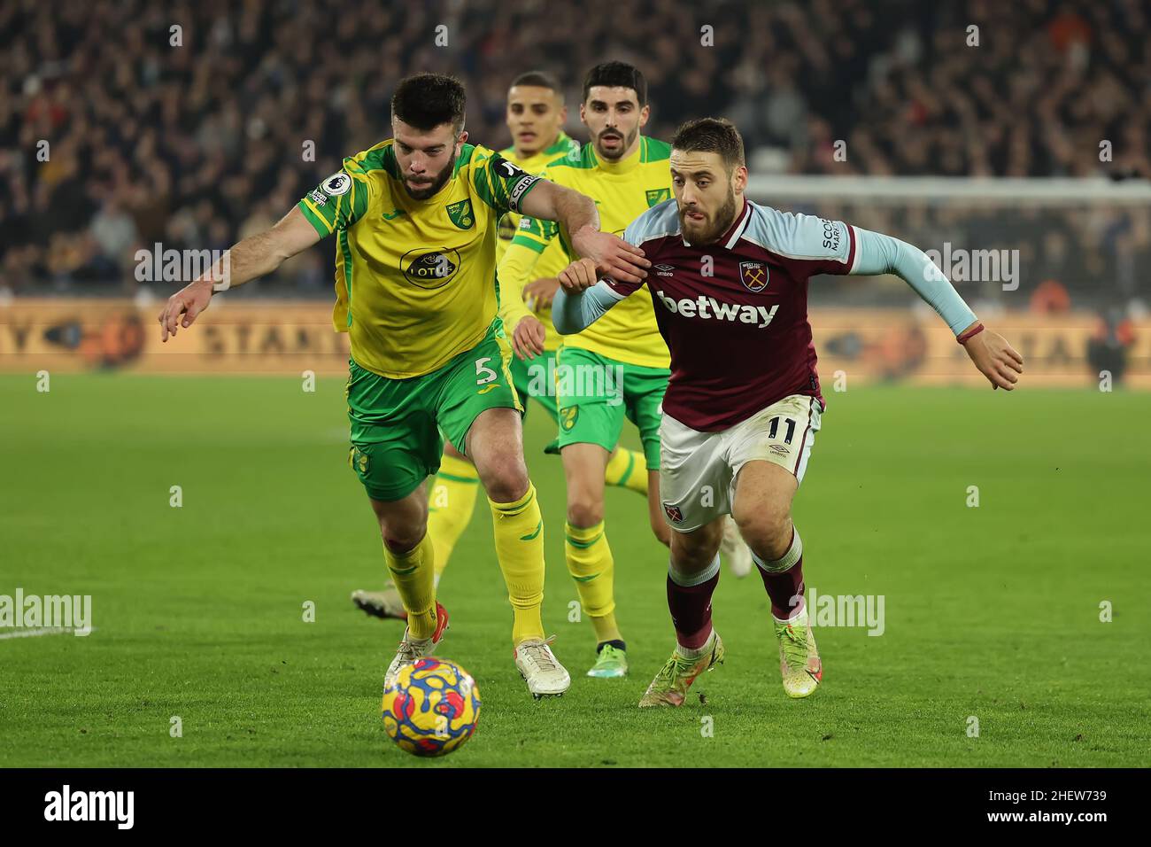 12th January 2022: London Stadium, London, England; Premier League football West Ham versus Norwich; Grant Hanley of Norwich City competes for the ball with Nikola Vlasic of West Ham United Stock Photo