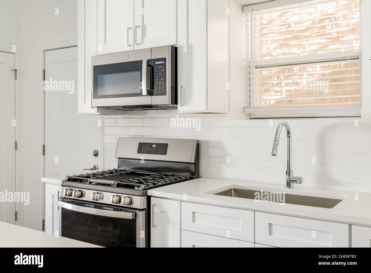 Modern White Condo Kitchen with Stainless Steel Appliances and Shaker