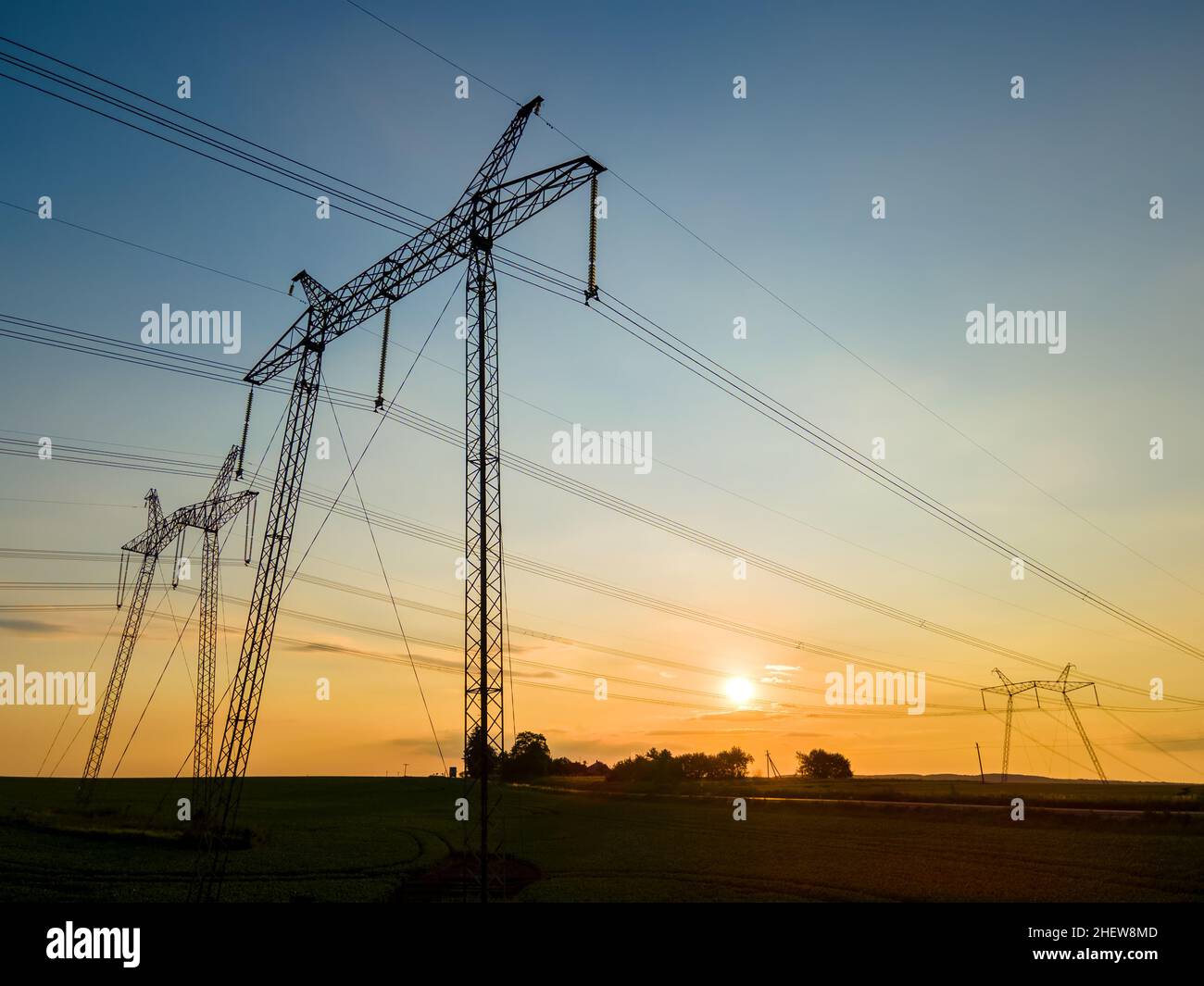 High voltage towers with electric power lines at sunset Stock Photo - Alamy
