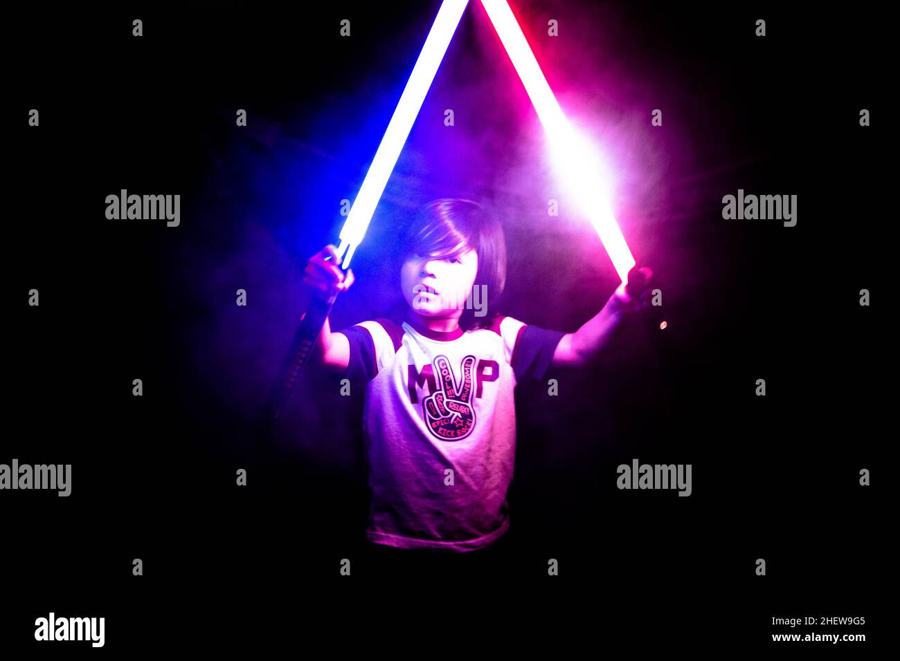 5 year old boy playing outside with lightsabers Stock Photo Alamy