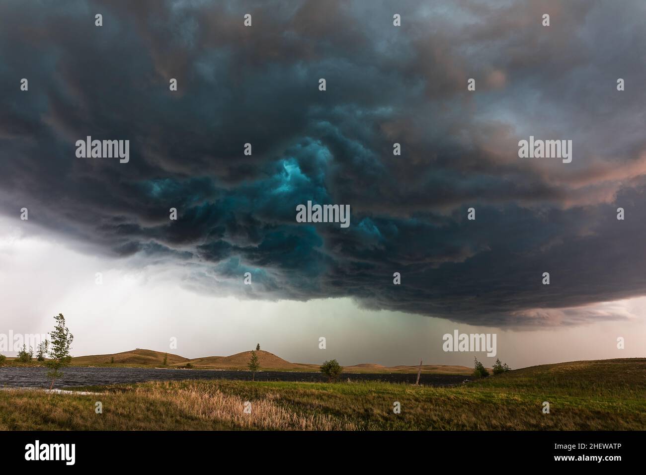 Dark, dramatic clouds and sky ahead of a severe storm over a lake in North Dakota, USA Stock Photo