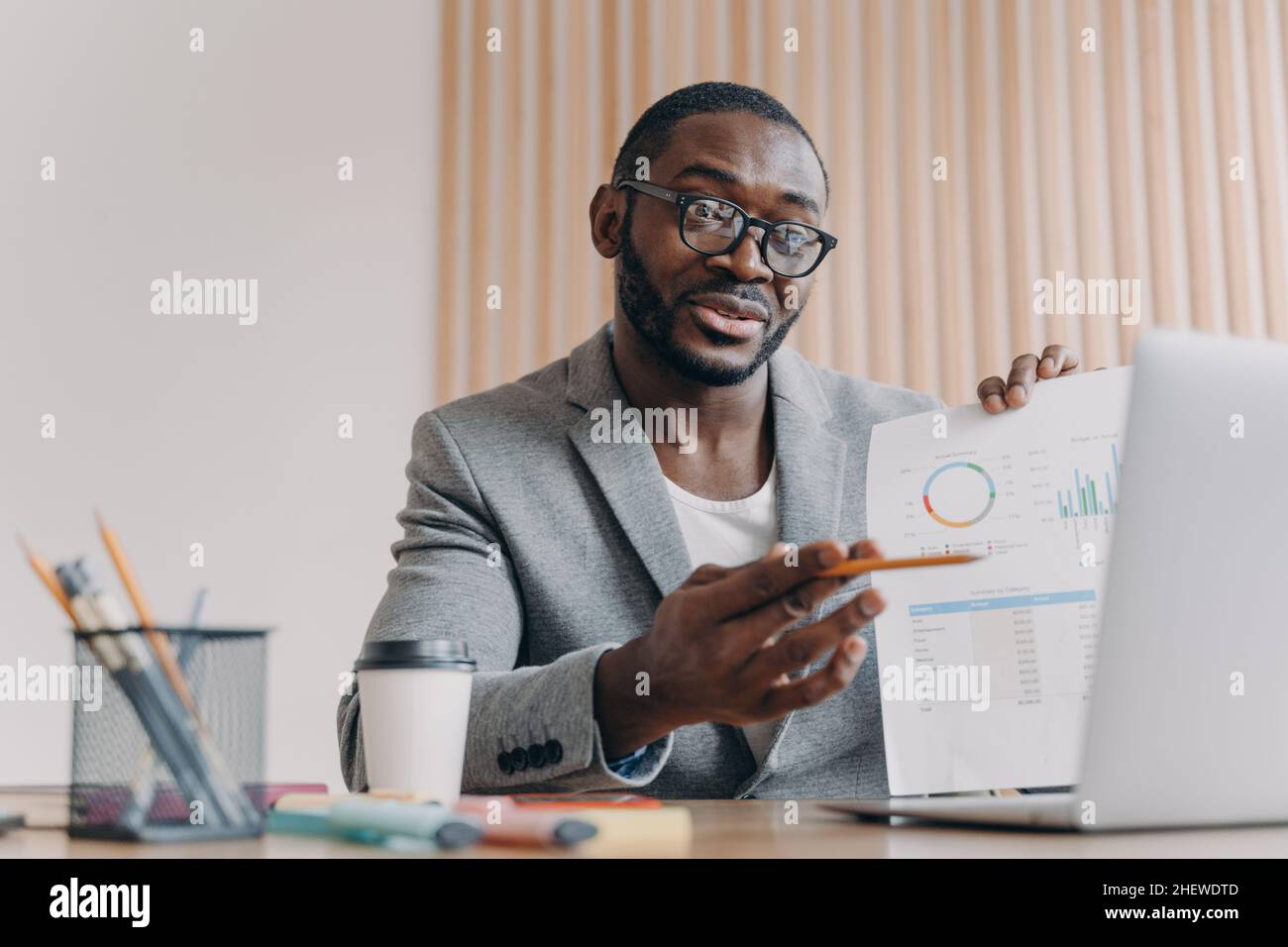 Young smiling african businessmen discussing income with partner via video call on laptop Stock Photo