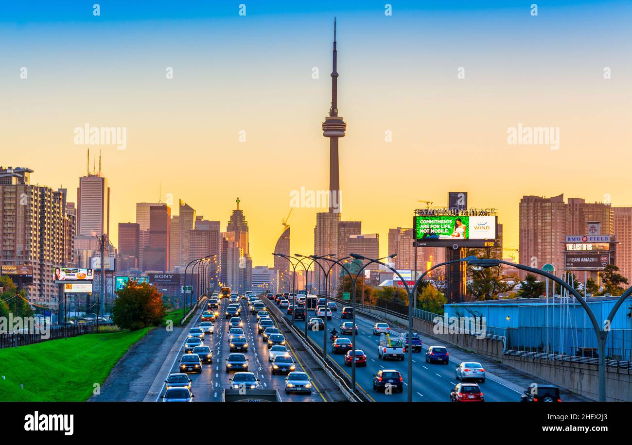 Gardiner expressway entering Toronto downtown at Dusk with CN Tower and other buildings in the background and two way traffic in the foreground. Stock Photo