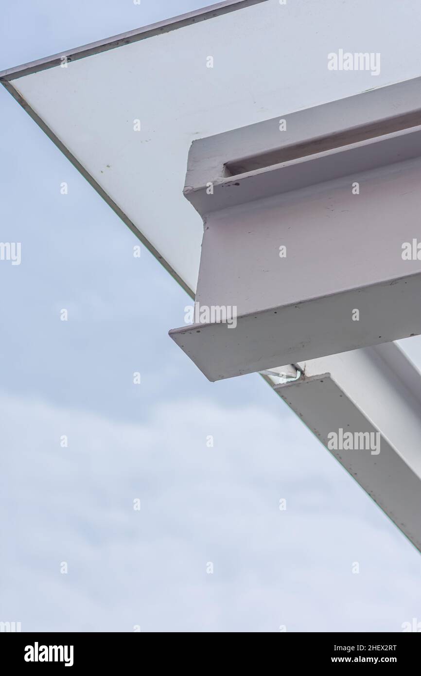 metal structure of white canopy with tempered glass covering upside under the clear and bright blue sky Stock Photo