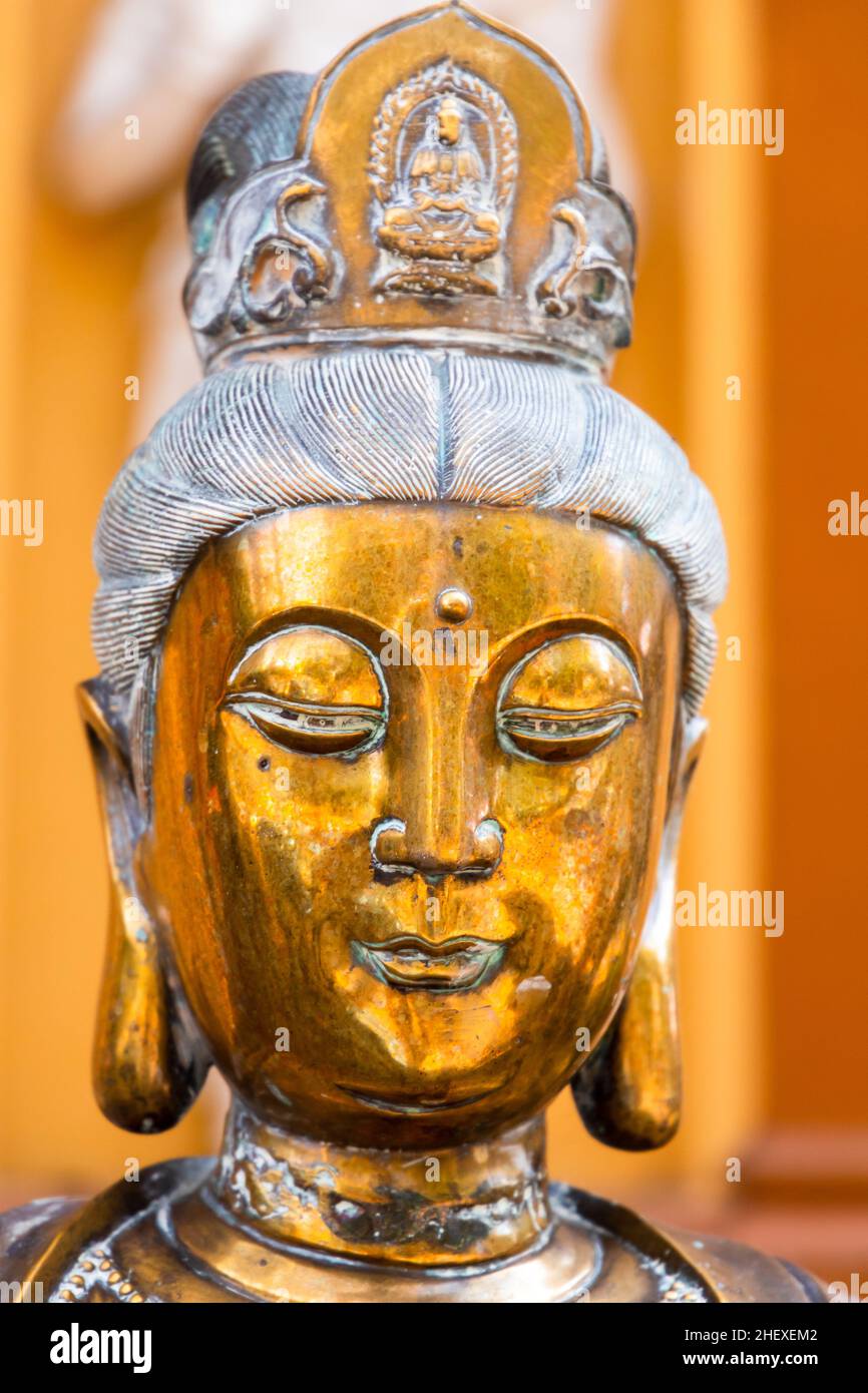 Face portrait of the ancient statue of Guanyin, Guan Yin or Kuan Yin. It is the Buddhist bodhisattva associated with compassion Stock Photo