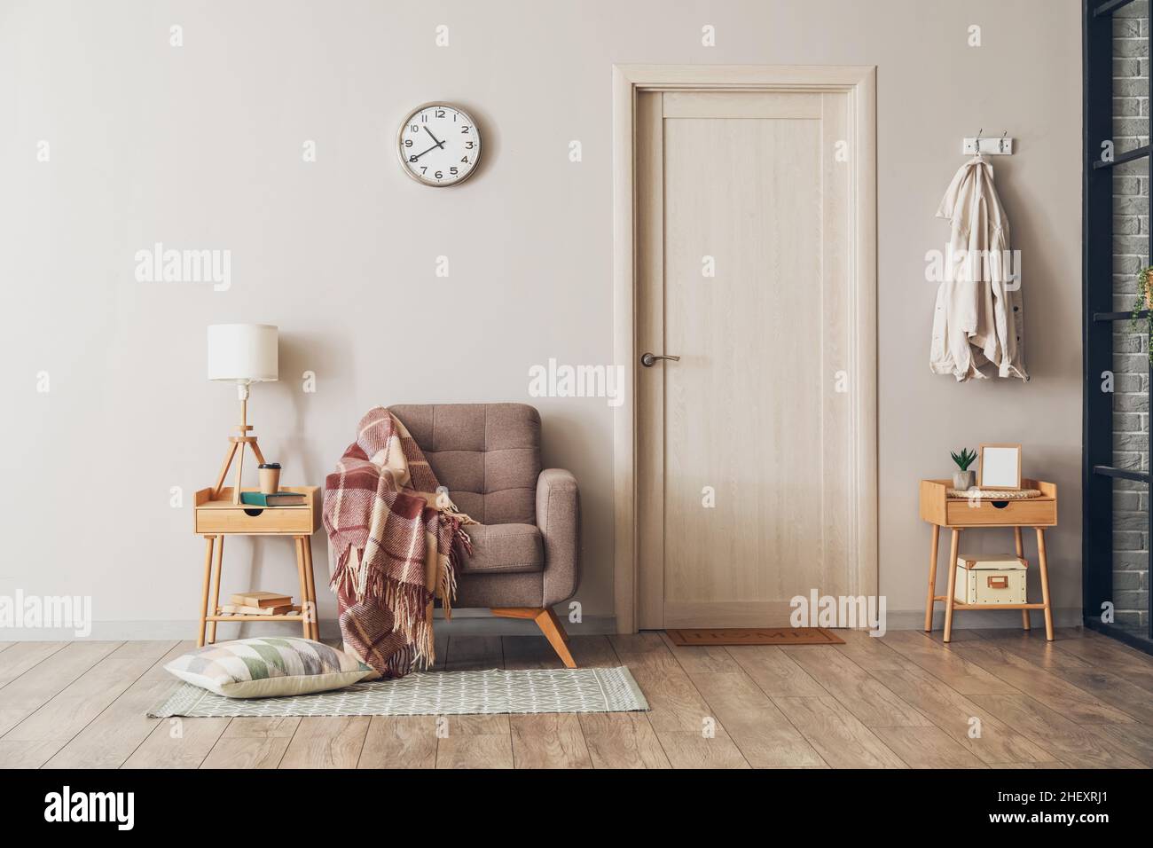 Interior of modern room with armchair and table near light wall Stock ...
