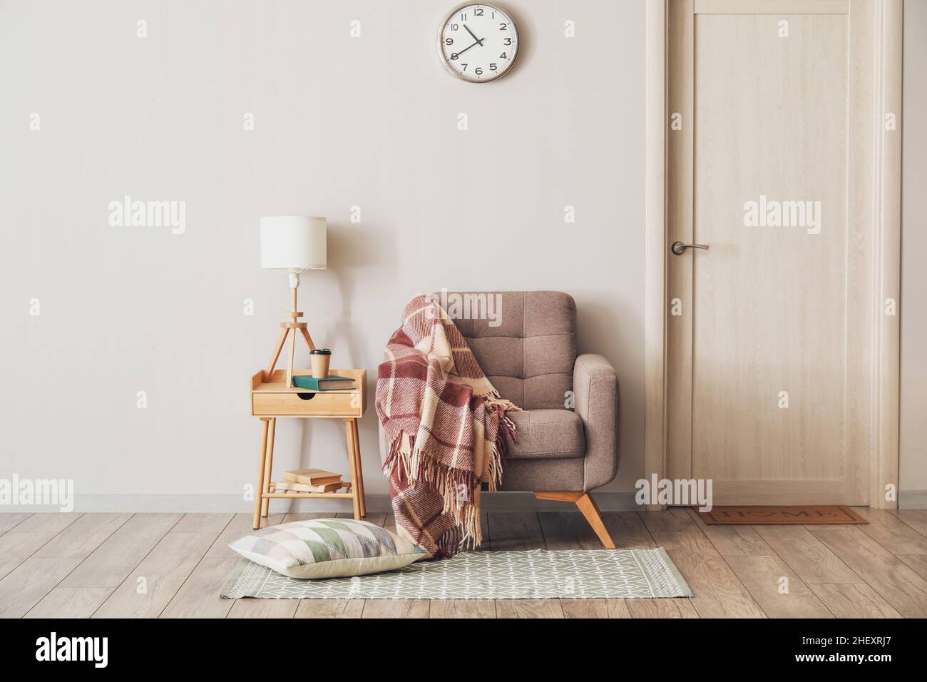 Interior of modern room with armchair and table near light wall Stock ...