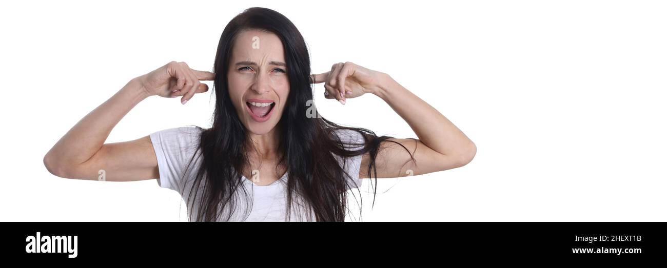Portrait of young screaming woman covering her ears with fingers. Stock Photo