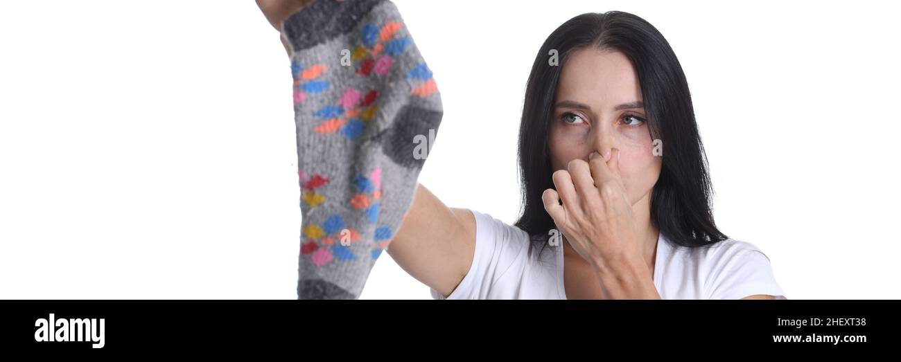 Portrait of young woman covering nose and holding sock in hand closeup Stock Photo