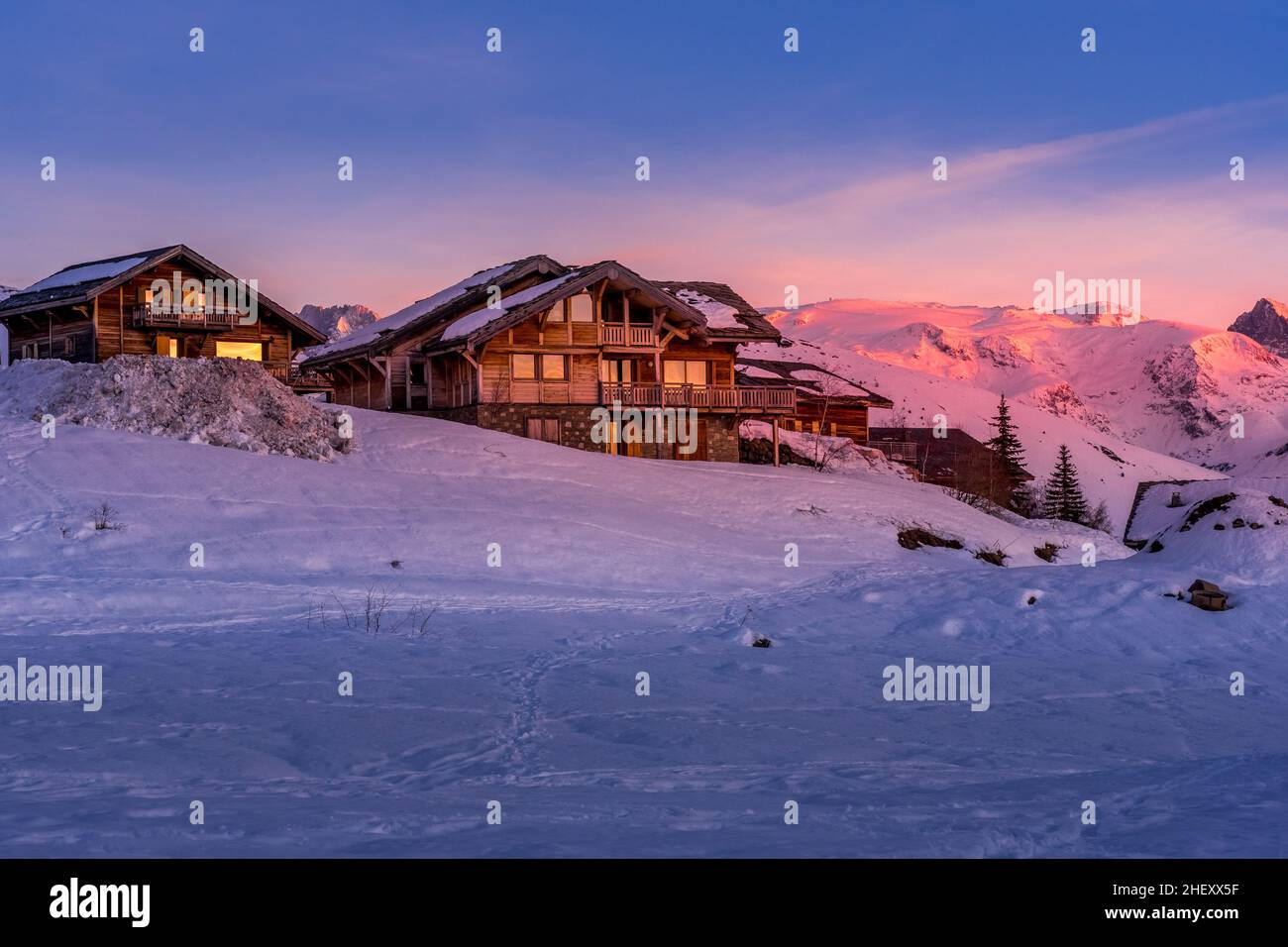 Alpine mountain winter resort with wooden chalet on the later evening