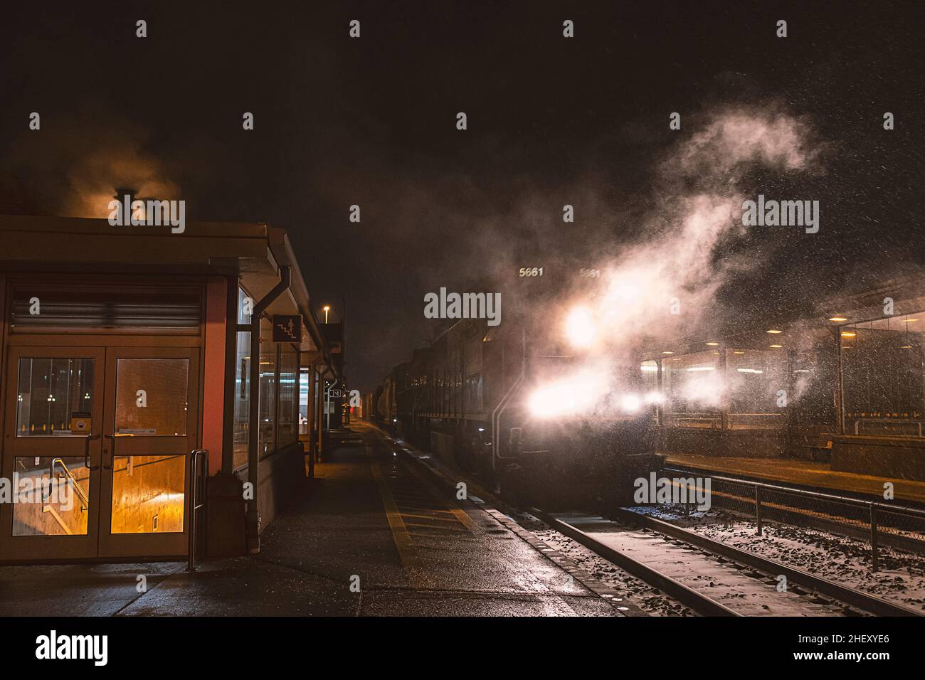 Caught this train coming through all this smoke one night at the station Stock Photo