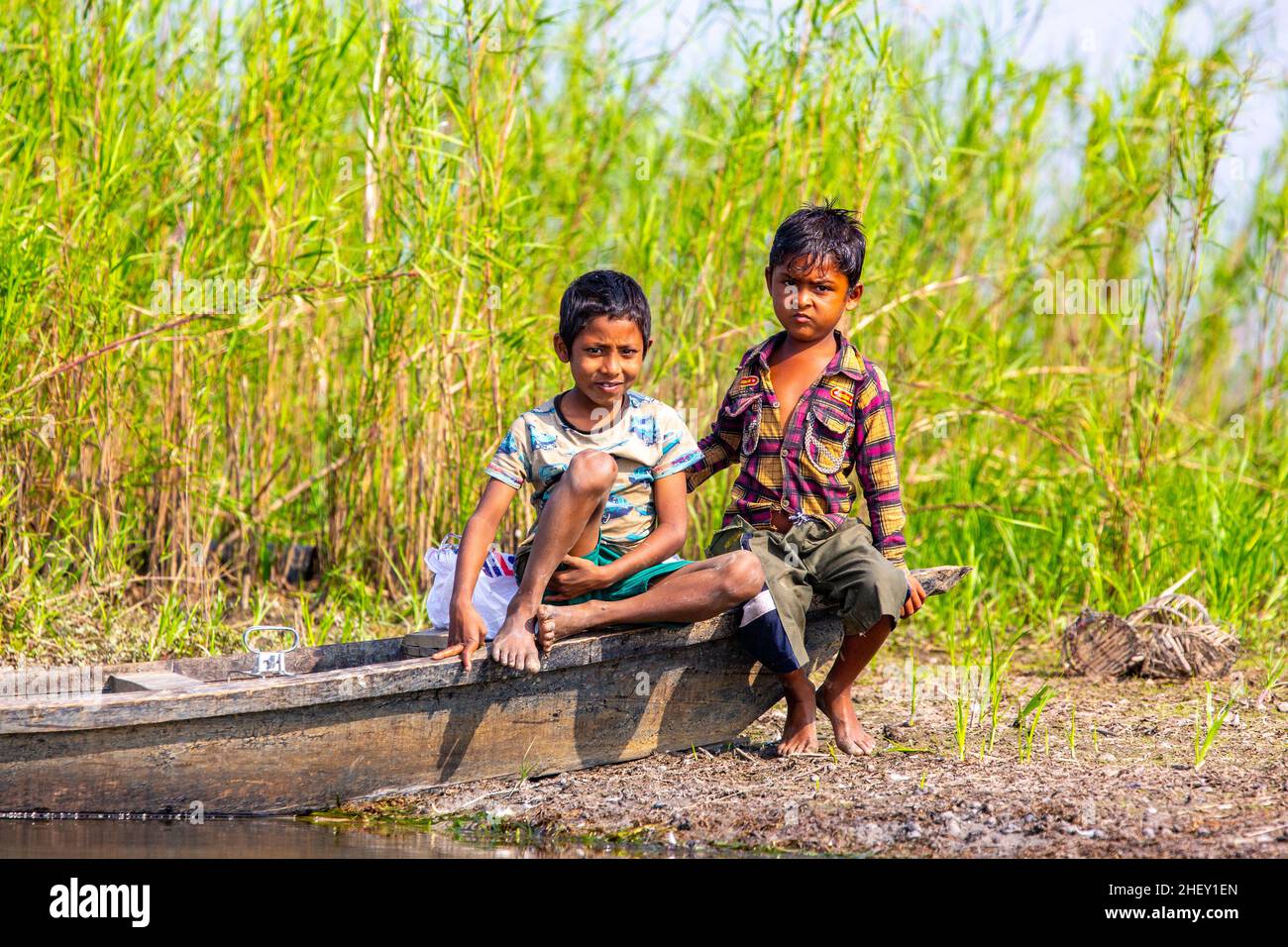 Bangladeshi rural boys sit on a boat at Tanguar Haor, Sunamganj, Bangladesh Stock Photo
