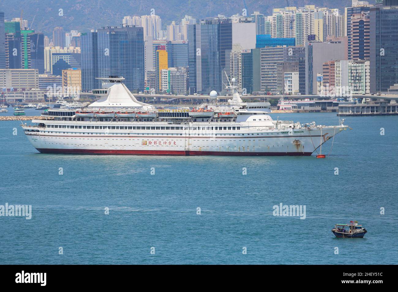 Cruise ship 'Oriental Dragon' in Hong Kong, South China, high-rise residential buildings, hills, floating casino vessel, cruises,passenger ships image Stock Photo