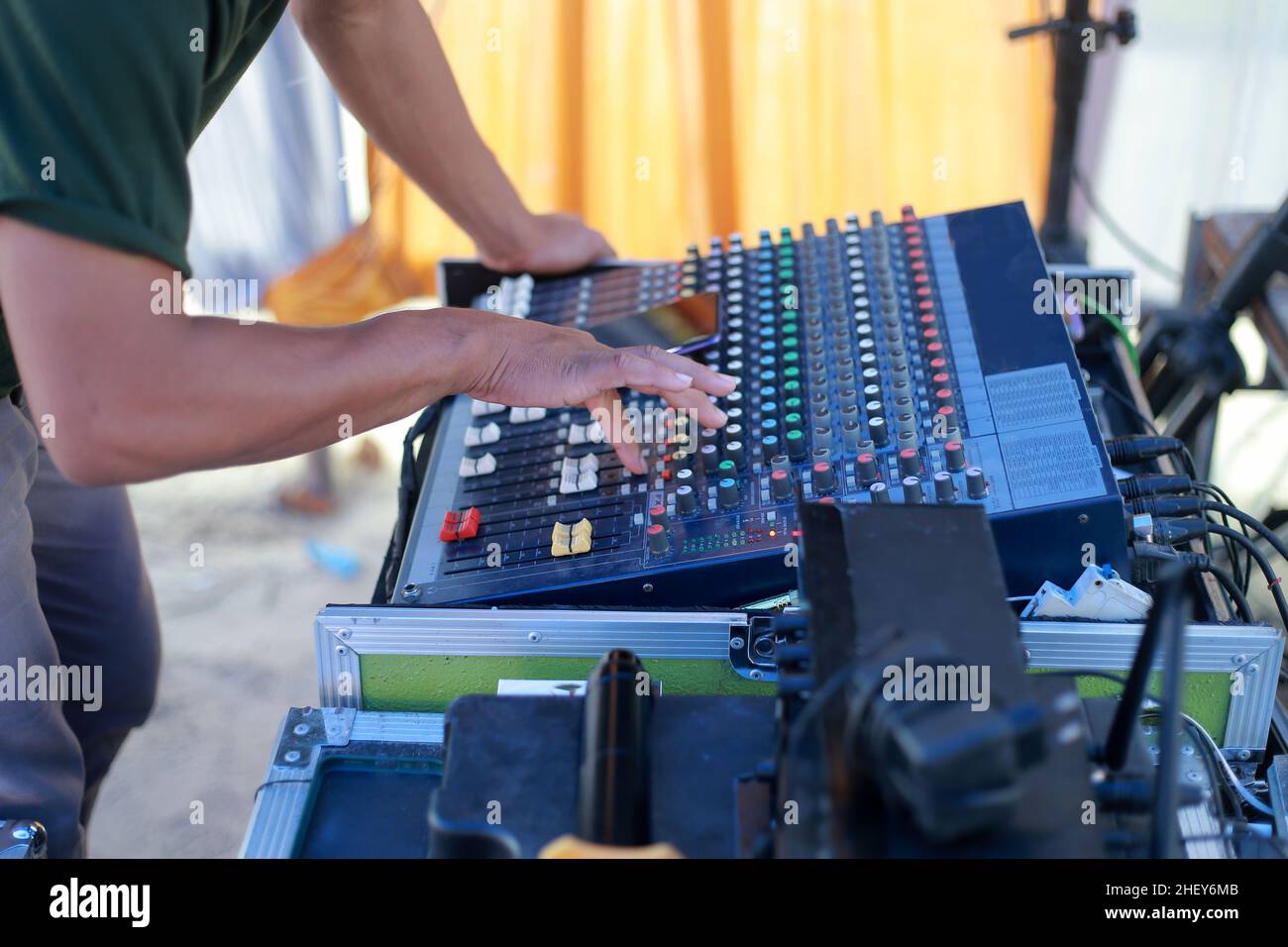 Sound system and a male sound engineer working on an audio mixing console Stock Photo