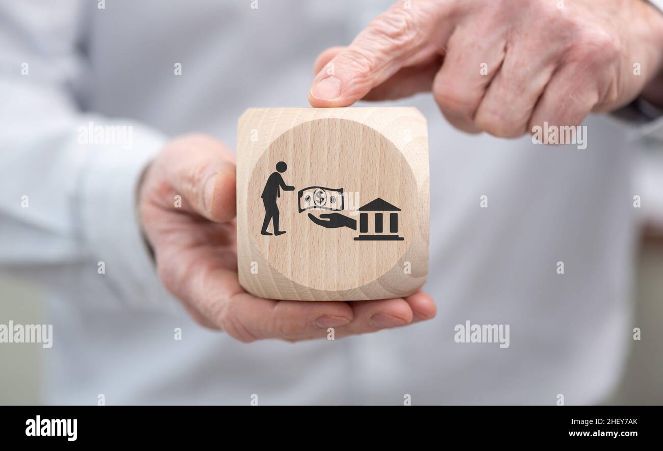 Hand holding a wooden cube with symbol of government aid concept Stock ...