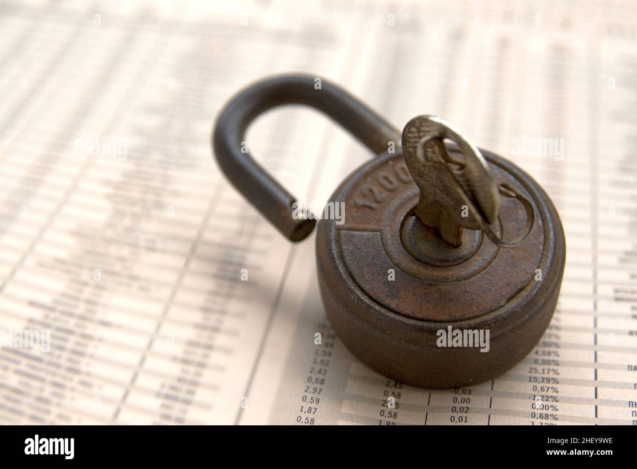 Economy newspaper with an old rusty padlock on it Stock Photo