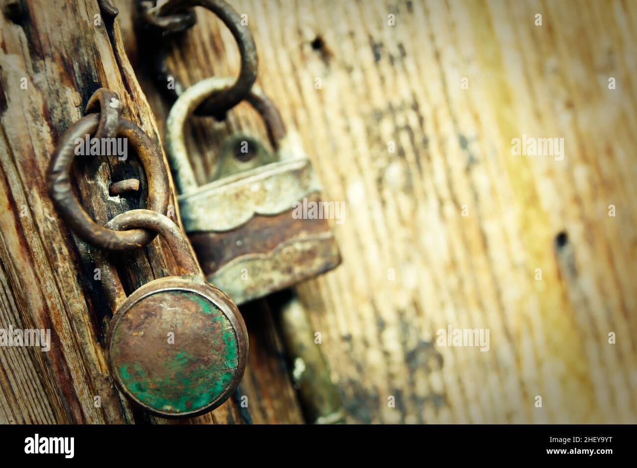 Two old padlocks on an old wooden door Stock Photo