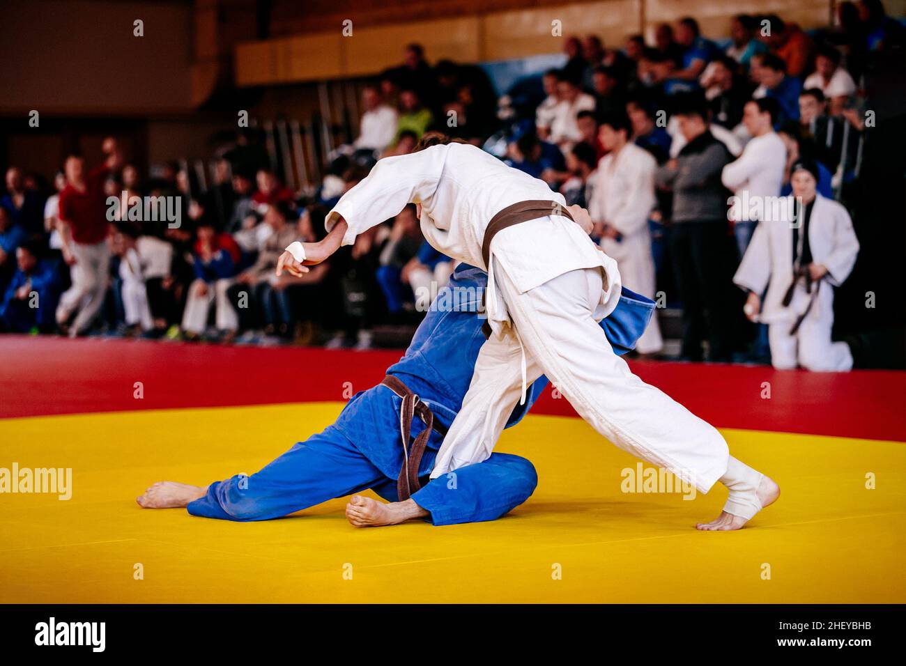 athletes judoists wrestling on tatami in judo competition Stock Photo