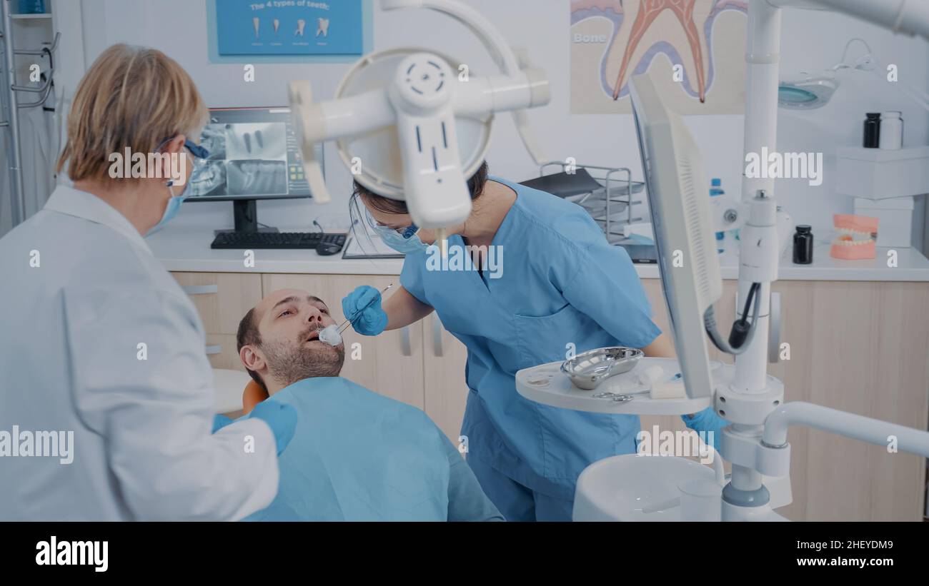 Dentistry team performing tooth extraction in stomatology