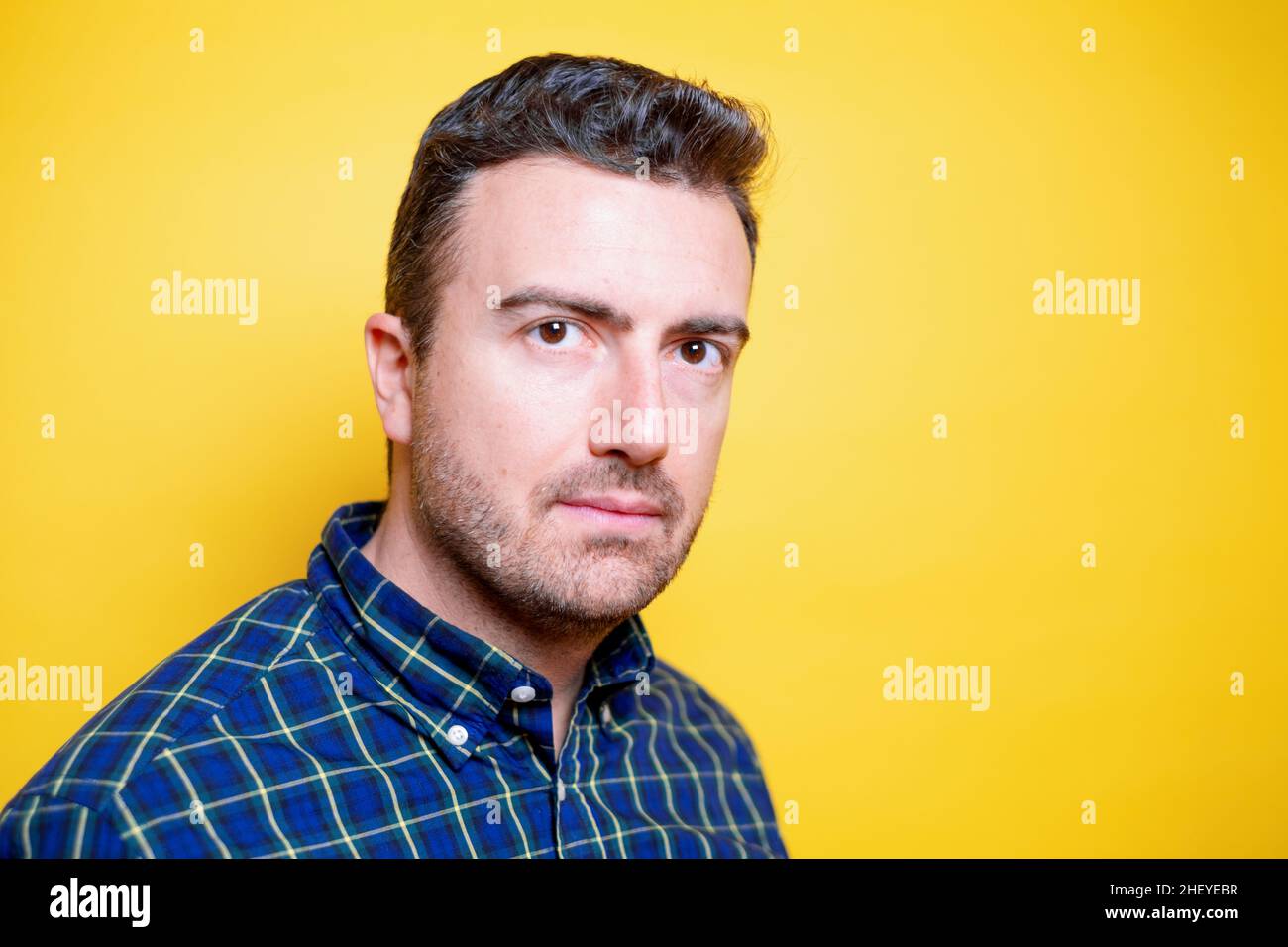 Face portrait of confident adult man on yellow background Stock Photo