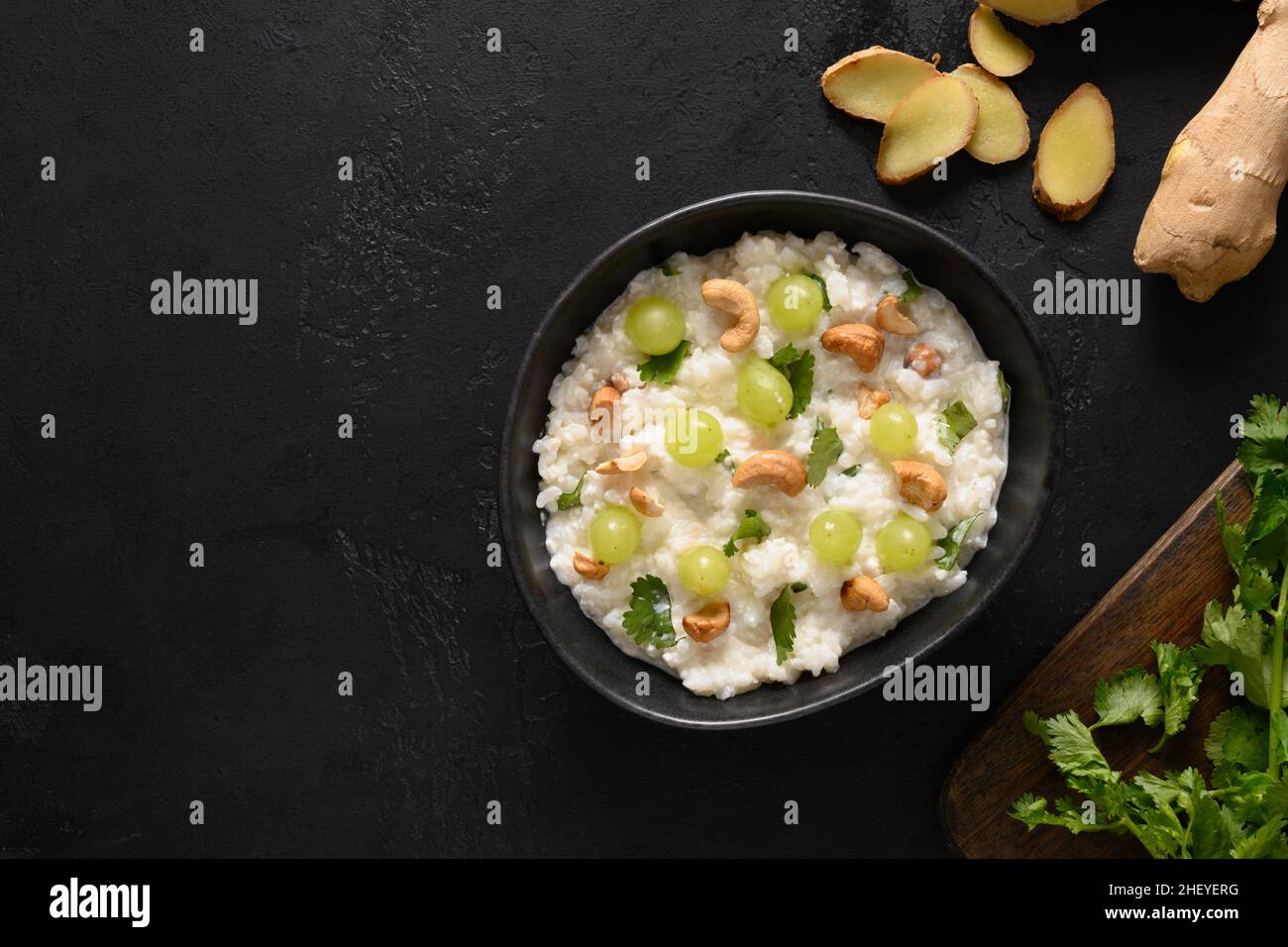 Homemade curd rice with cashews, cilantro and ginger. View from above. Indian South ayurvedic cuisine. Copy space. Indian dinner. Stock Photo