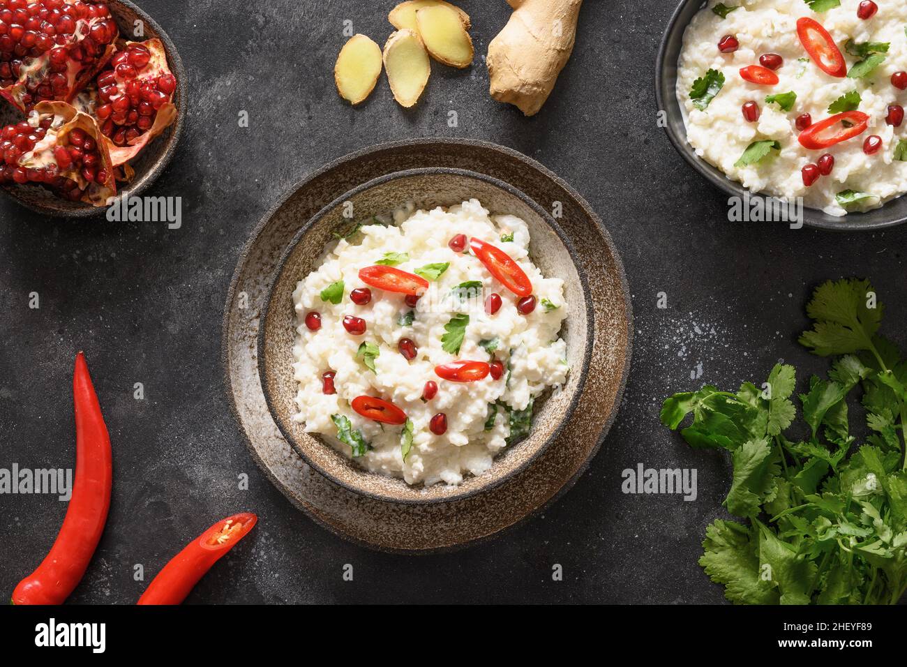 Curd rice with pomegranate, spicy, ginger on dark gray background. Top view. Indian cuisine. Stock Photo