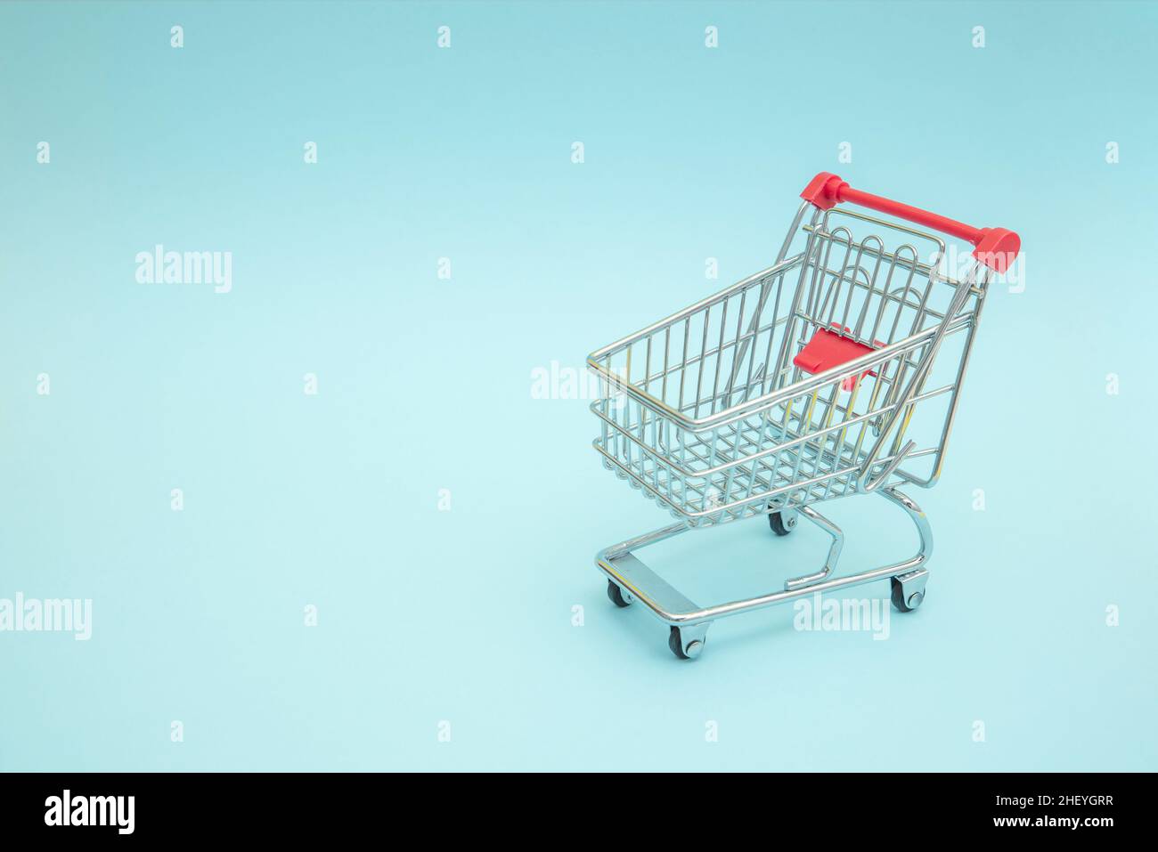 Empty shopping trolley with blue background Stock Photo
