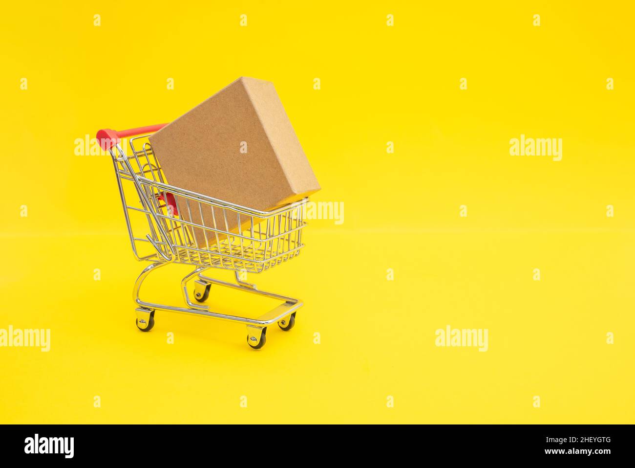 Shopping trolley with cardboard box. Copy space for promo text Stock Photo