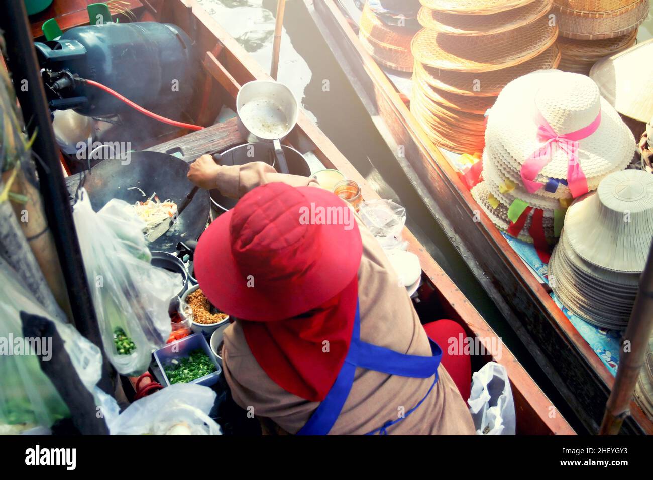 Food vendor at the Damnoen Saduak Floating Market preparing Thai food Stock Photo