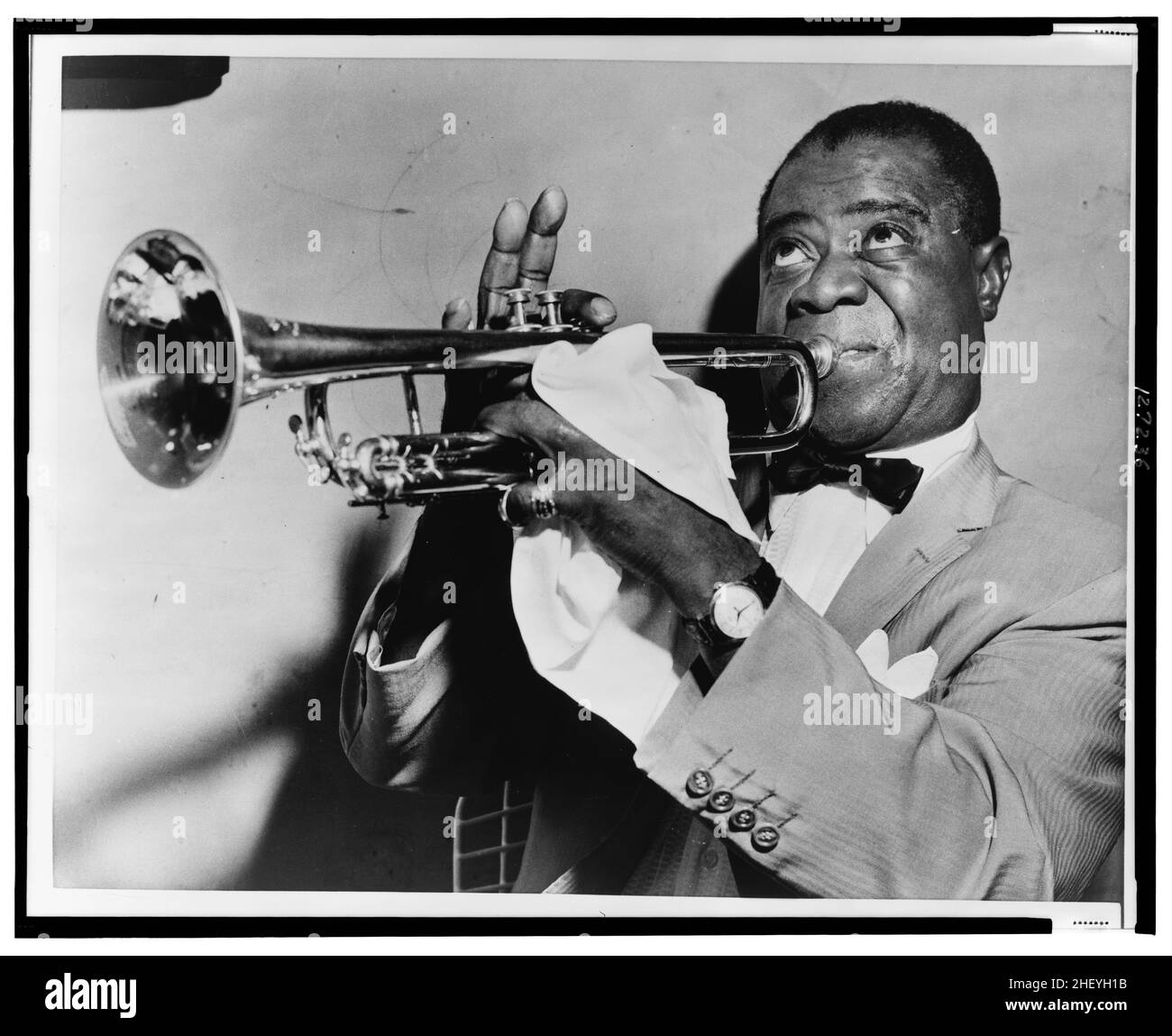 Louis Armstrong, head-and-shoulders portrait, facing left, playing trumpet, 1953 Stock Photo