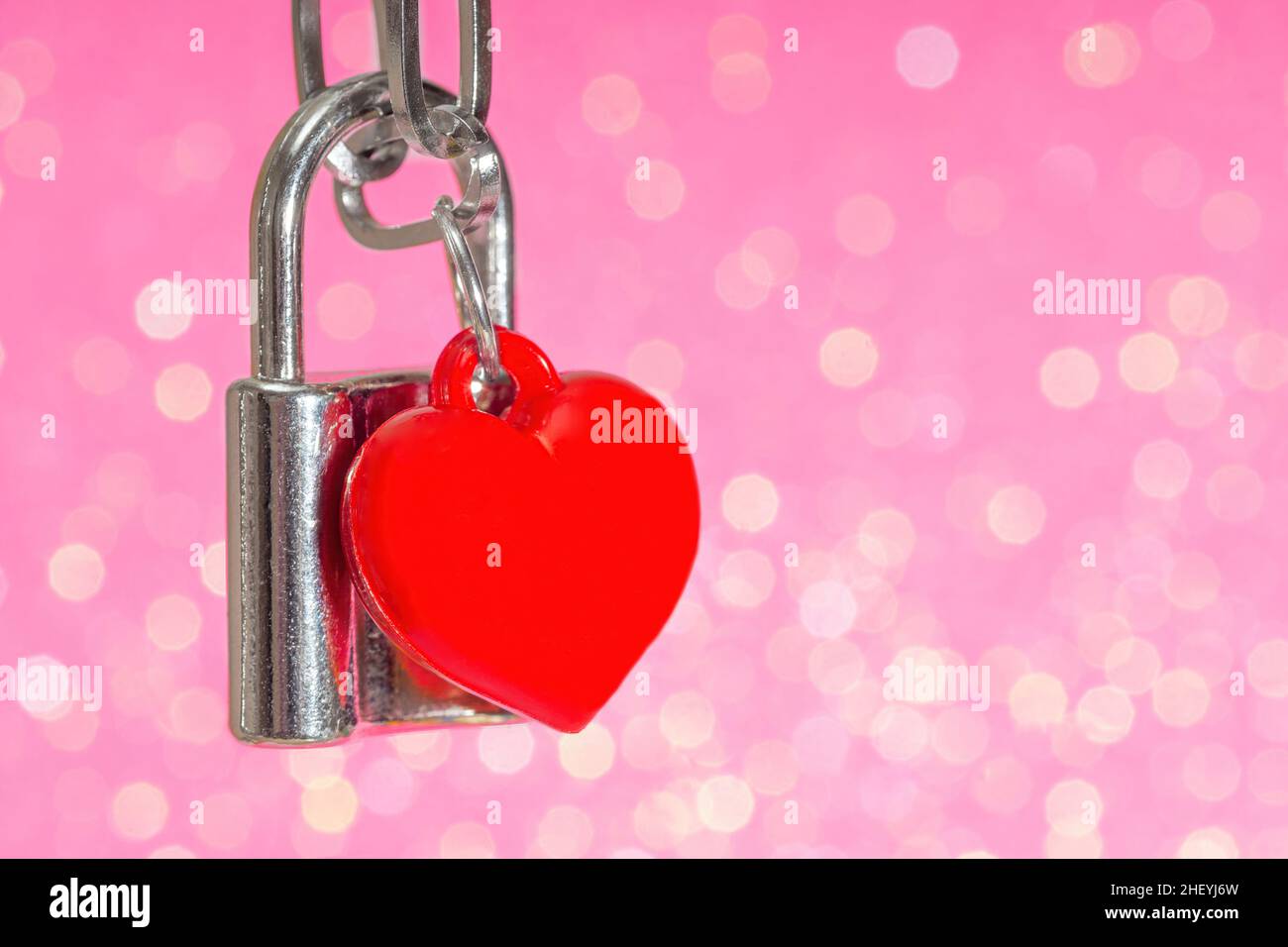 Close-up of a locked padlock with a red heart shaped pendant against a pink  background. Romantic St. Valentines card concept Stock Photo - Alamy