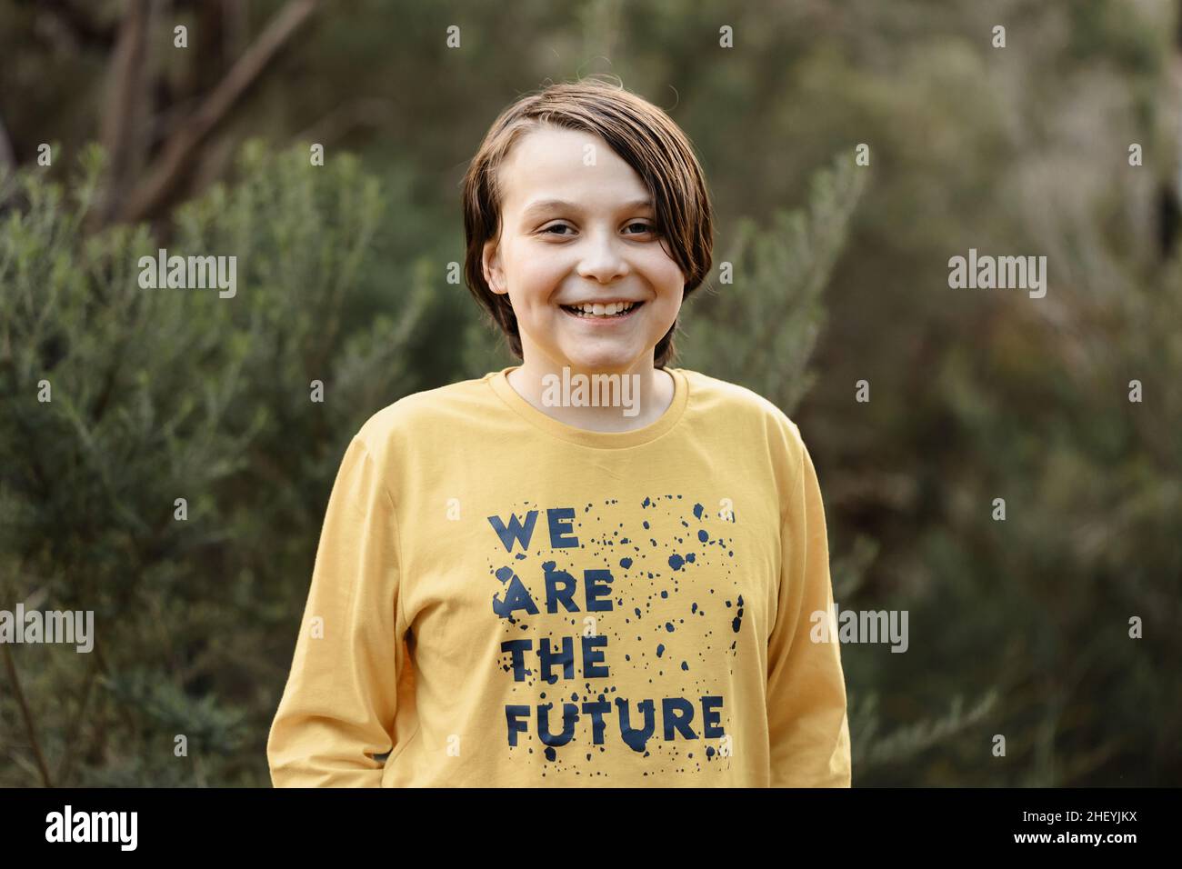 Boy wearing a generic yellow T-shirt that says we are the future Stock Photo