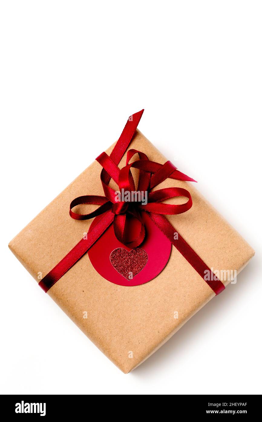 Elegant design of present gift box wrapped in brown craft paper with red ribbon, top view on white background Stock Photo