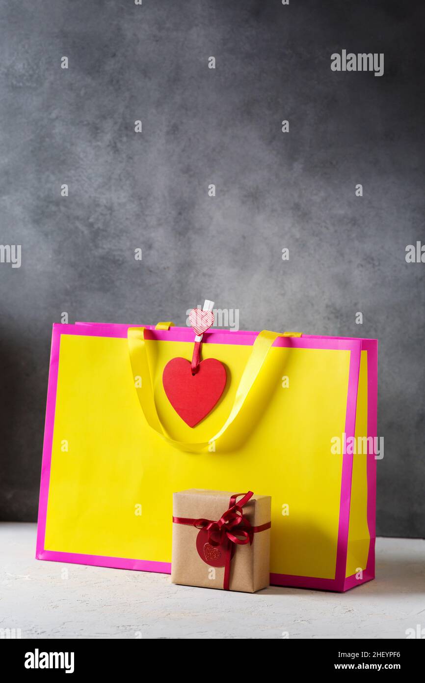 Valentines day present gift bag in bright colors pink and yellow with little wrapped present box, mockup Stock Photo