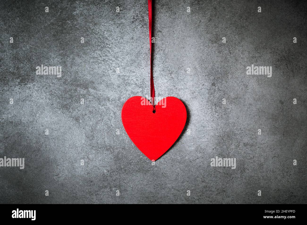 Minimalistic decoration, red heart over textured grey background, trendy minimal Saint Valentine day card Stock Photo