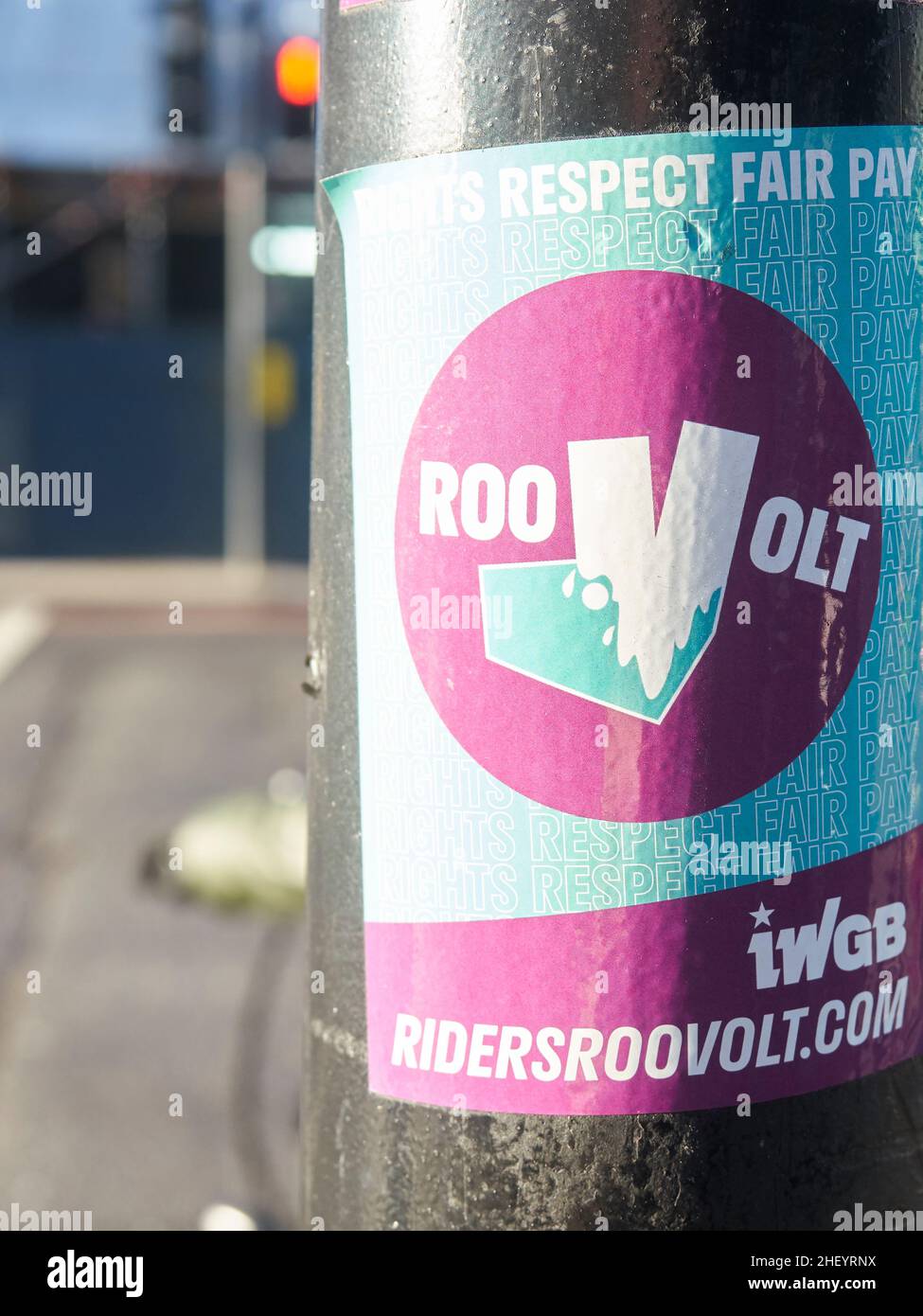 Political expression on the streets of London, UK - A sticker on a London traffic light urging unionisation and pay reforms for gig-economy workers. Stock Photo