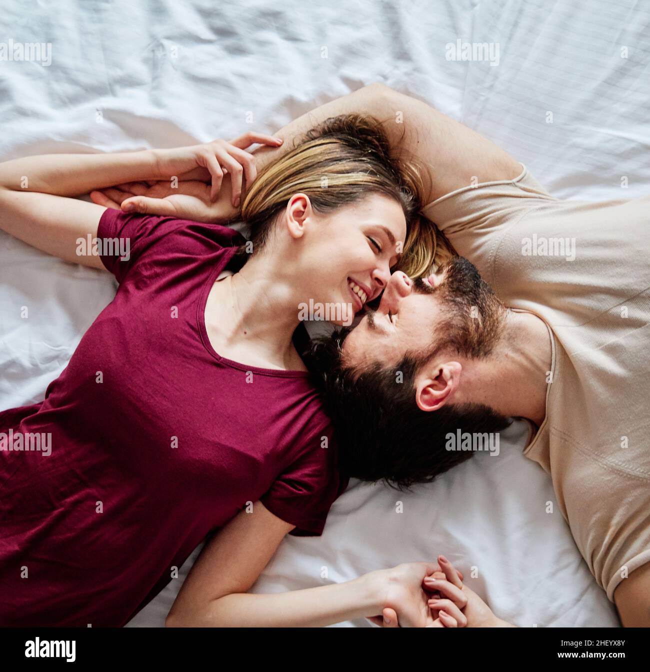 couple love bedroom bed lying romance happy relationship valentine day together man woman Stock Photo