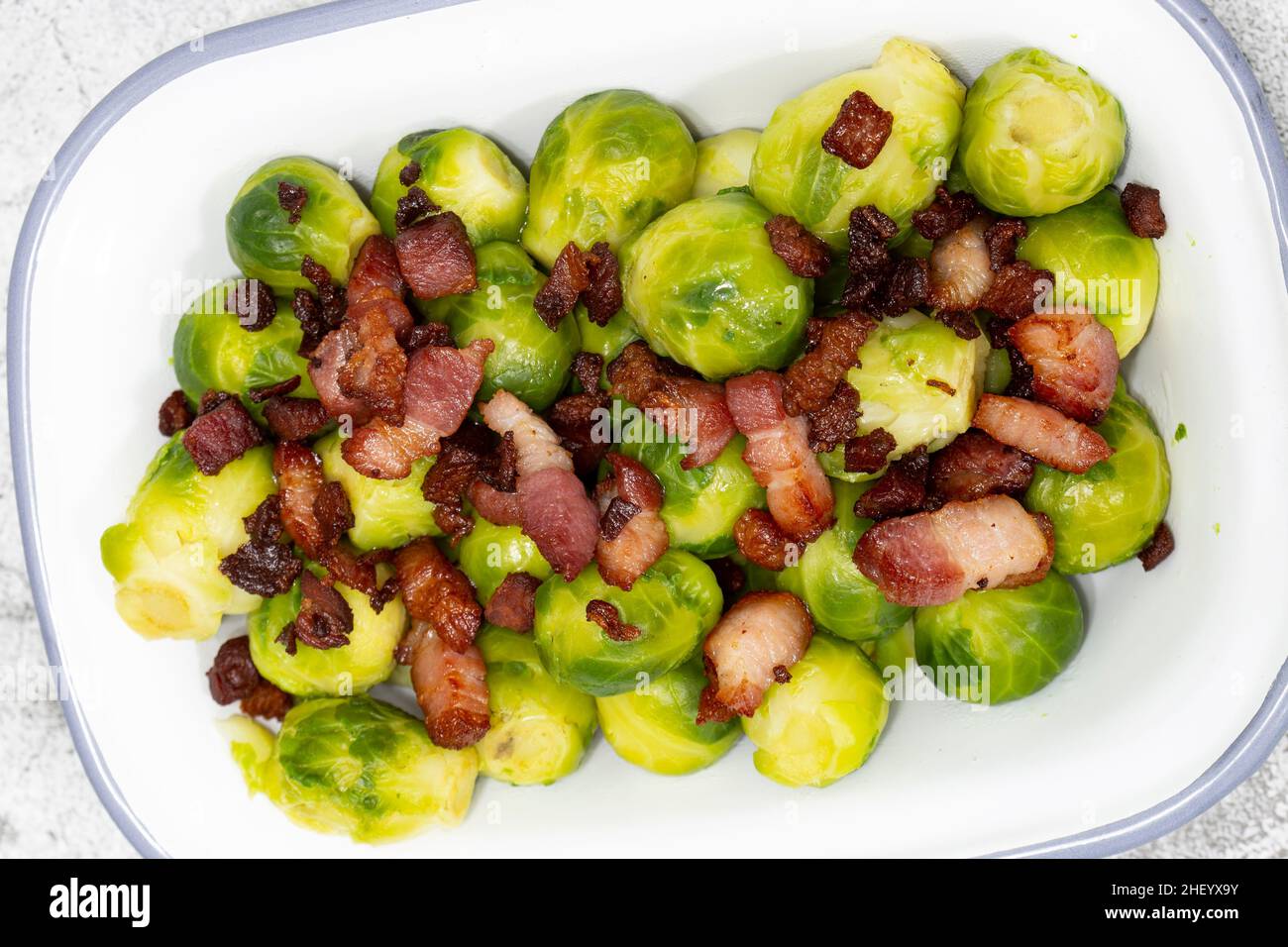Brussels sprouts with bacon lardons in a traditional enamel dish. On a