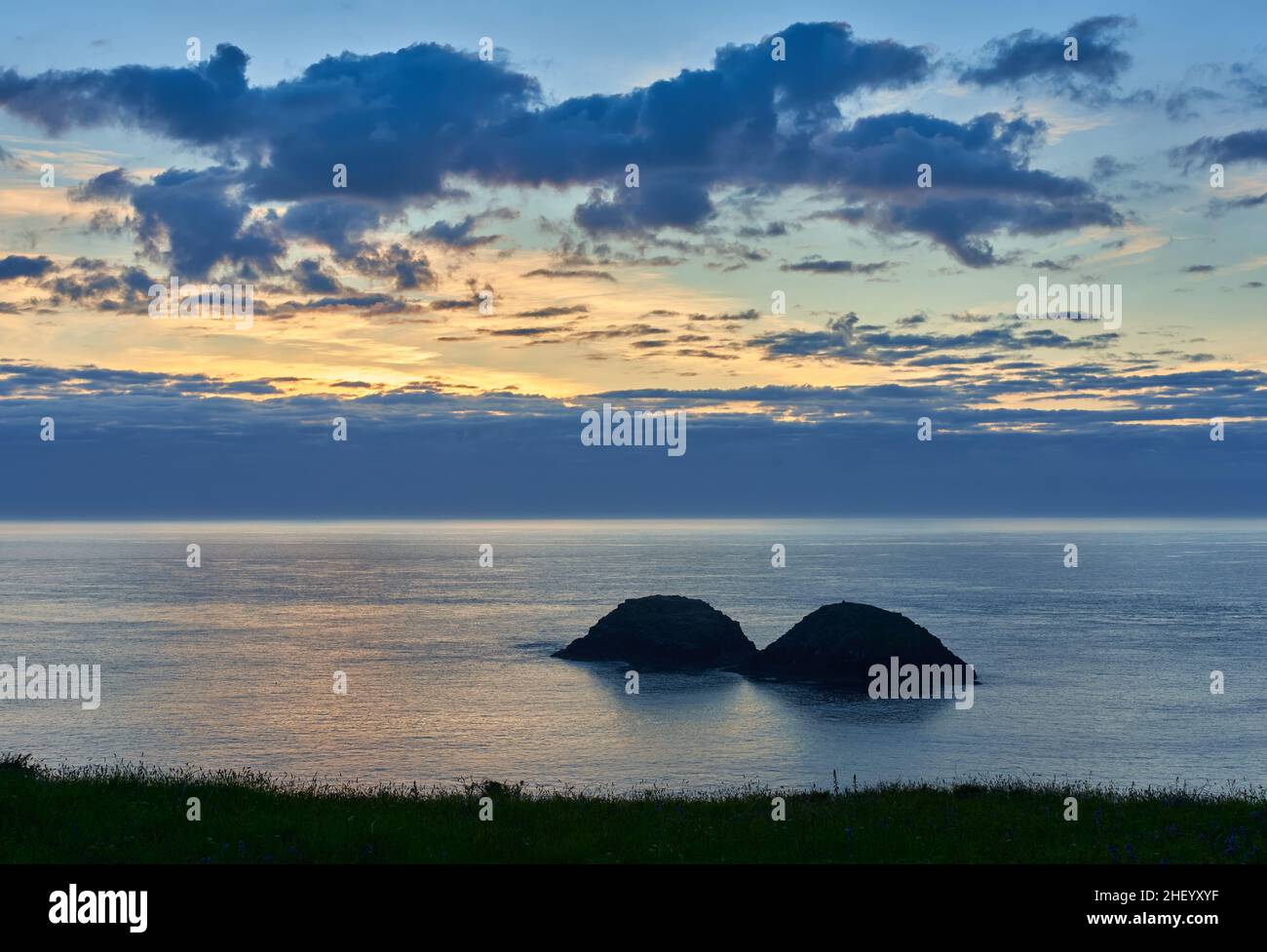 Twin islands of Cerrig Gwylan off Treath Llyfn on the Wales Coast Path in Pembrokeshire UK at sunset Stock Photo