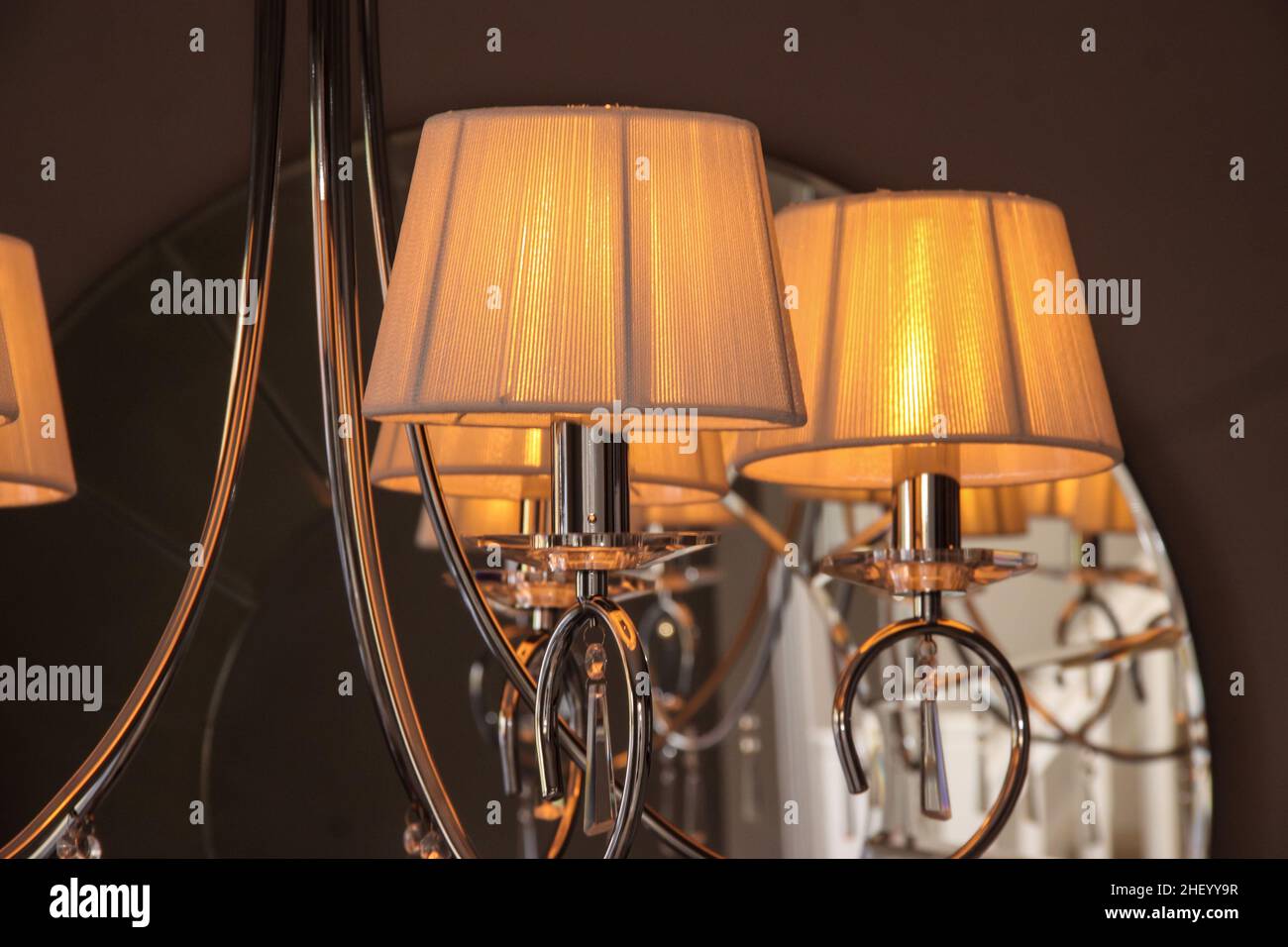 Golden yellow lampshades on a modern chandelier type light fitting with